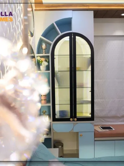 A closer look at the arched display cabinet and vanity area, seen through the reflection of the stunning floral chandelier.
