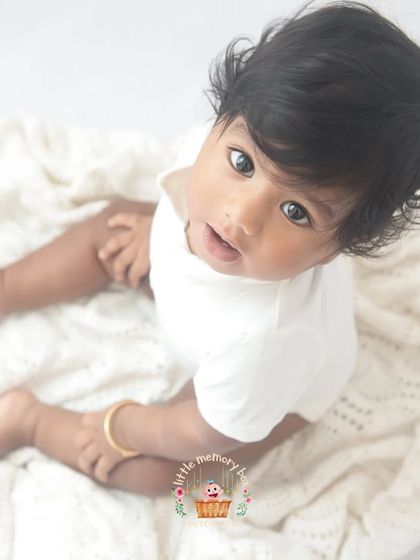 Another angle from this minimalist sitter session. The focus is entirely on the baby's sweet face and curious gaze. These are the portraits that stand the test of time.