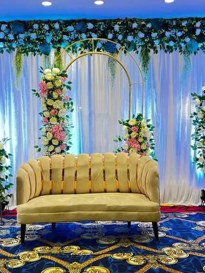 A cool-toned stage design with blue lighting and floral-decorated arches. This setup offers a unique and refreshing alternative to traditional wedding colors.