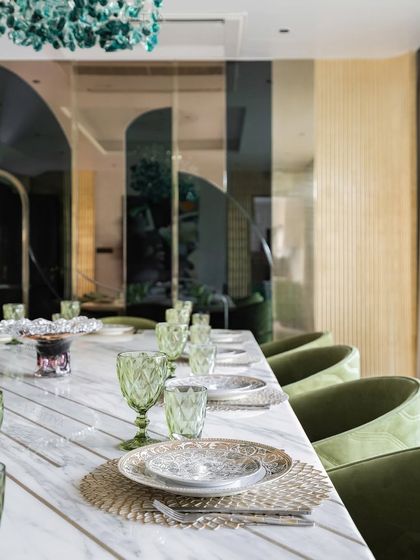 A view of one of our elegantly styled dining rooms. We focus on combining statement lighting, comfortable seating, and high-quality materials like marble and brass to create spaces that are perfect for both everyday meals and special occasions.
