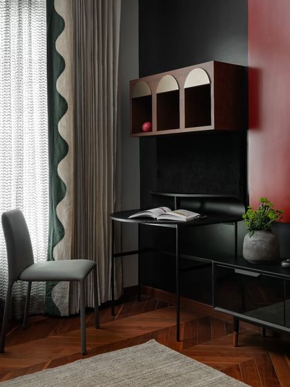 We designed this study nook in the guest bedroom with calm confidence in mind. The space features a minimalist desk, a floating arched cabinet, and elegant scalloped curtains, blending subtle thematic nods with timeless design for a space that is both creative and enduring.