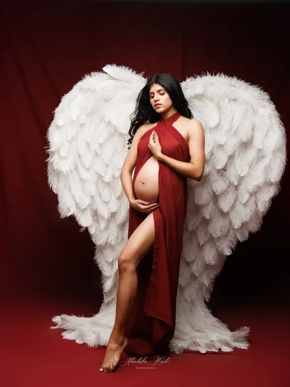 A full-length view of the dramatic angel wings and red fabric drape, creating a powerful and unforgettable artistic statement.