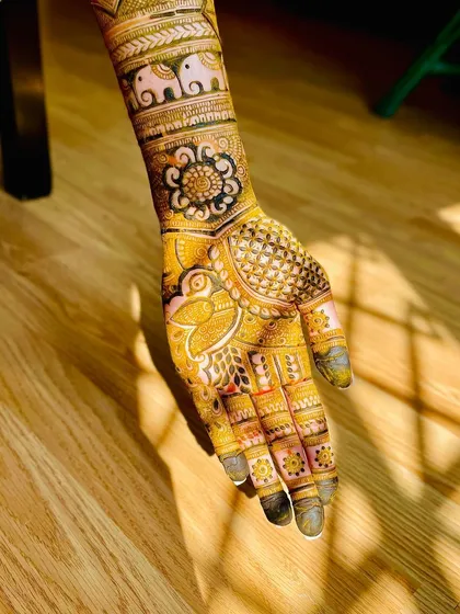 Sunkissed henna showing a beautiful elephant band on the wrist, paired with a floral mandala. This highlights the rich color of the natural henna paste.