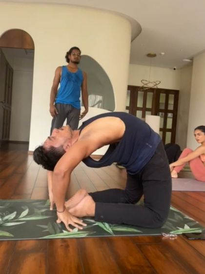 A student works on Ustrasana (Camel Pose) during a backbend workshop. This pose is a powerful heart opener that stretches the entire front of the body.