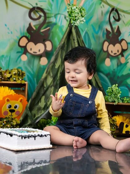 A sweet, contemplative moment from a jungle-themed cake smash, as the birthday boy enjoys his cake.