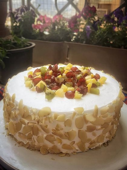 My fresh fruit cake is a celebration of summer. Topped with a colorful medley of seasonal fruits like kiwi, grapes, and pineapple, and coated with crunchy almonds, it's as beautiful as it is delicious.