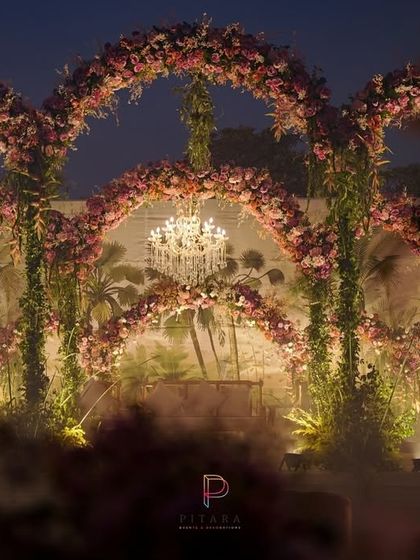 A wider view of the floral arches, creating a romantic and dreamy backdrop for the evening's celebrations. The soft lighting makes the entire setup feel like a fairytale.