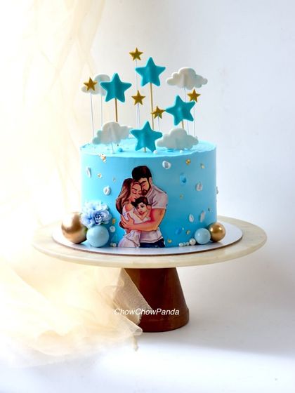 A sweet cake for a new dad's birthday, featuring an illustration of a family. This blue cake is topped with clouds and stars for a dreamy feel.