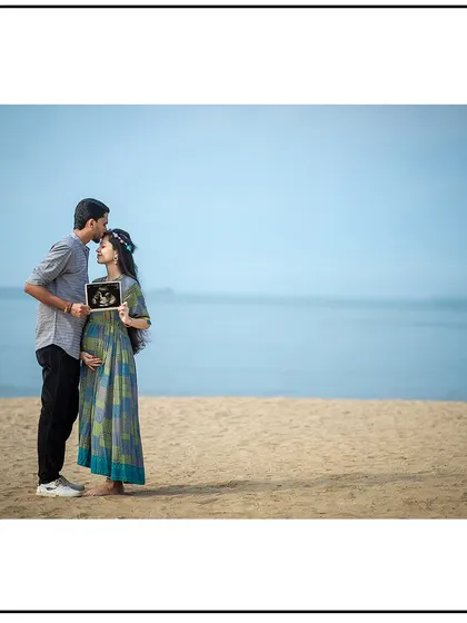 Your photoshoot can be anywhere you dream of, including a serene Mumbai beach. This couple's portrait by the sea, featuring their baby's first picture, is a perfect example of a personalized location shoot.
