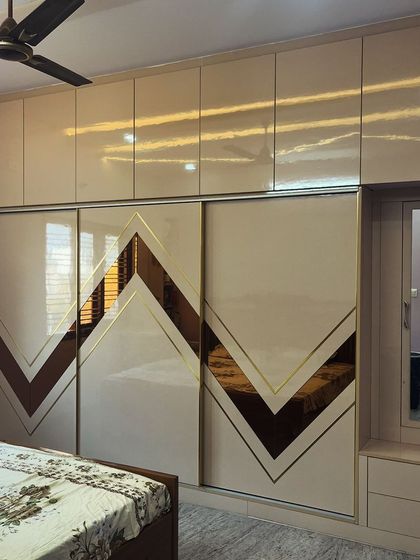 This sliding wardrobe features tinted beveled mirror panels with golden T-patti inlay. This combination adds a factor of "aww" and makes the entire room feel more luxurious and spacious.