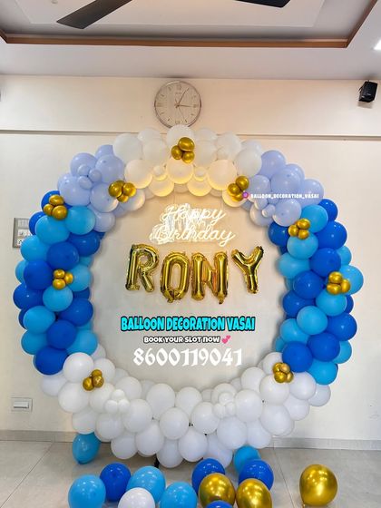 A birthday ring decoration with custom foil letter balloons. The blue, white, and gold color scheme is bright and cheerful.