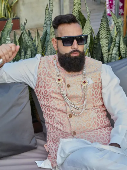 A relaxed yet regal pose in the light peach brocade waistcoat. The subtle details and luxurious fabric speak volumes, perfect for a wedding day.