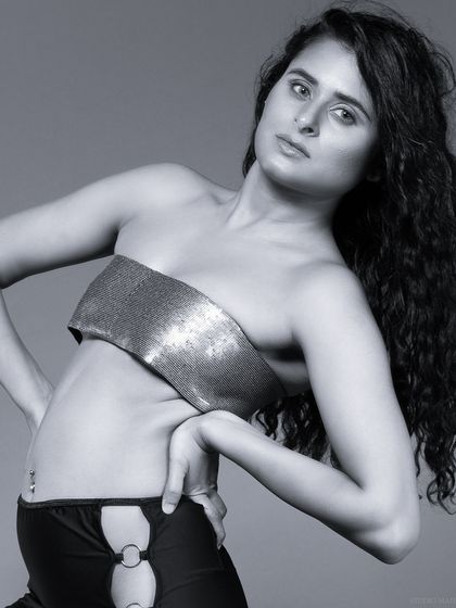 A black and white close-up, focusing on the model's expression and the texture of the top.