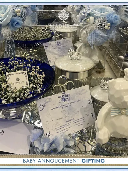A complete baby announcement gifting set for a boy. This image shows the full silver tray arrangement, including the personalized card, teddy bear, chocolate box, and silver keepsake jars, all tied together with a blue floral theme.