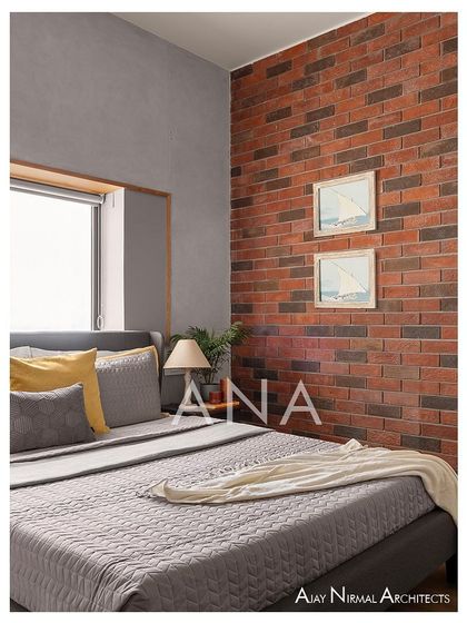 A guest bedroom in Apartment 704, featuring a striking raw brick wall. The room is designed with a minimal color tone and sleek furniture to create a pleasing and artful space for visitors.