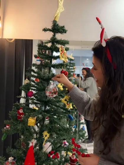 Carefully placing ornaments on the tree. Every little detail adds to the magical holiday atmosphere in the studio.