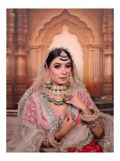 A mid-shot of the bride, highlighting the contrast of the red lehenga and the silver-white dupatta.