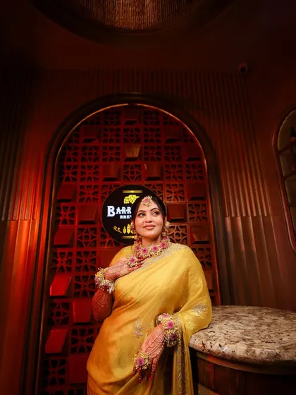 The bride poses during her haldi ceremony, her makeup fresh and radiant.