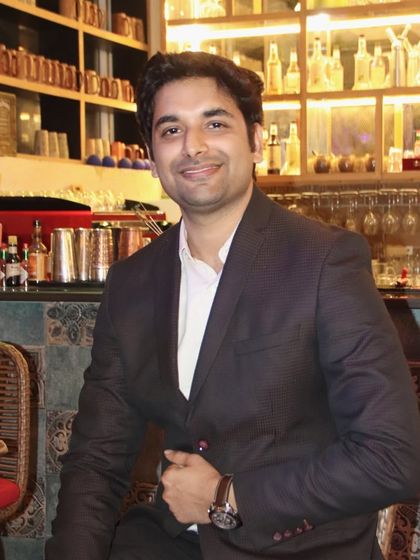 A man posing for a portrait at a bar or restaurant. I am skilled at using the environment to create interesting backgrounds for photos.