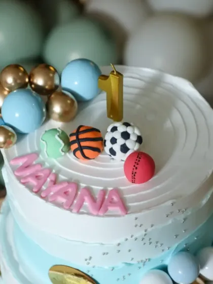A close-up of the sports ball themed cake, showing the mix of fondant balls and decorative spheres.