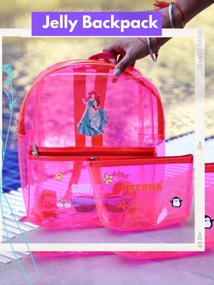 A personalized pink jelly backpack and matching pouch set. The backpack is decorated with a princess patch, while the pouch has the name 'Prerna' and other fun charms.