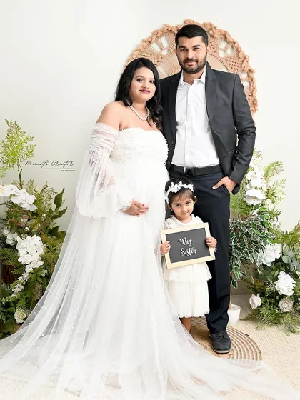 A complete family portrait in the boho-floral setup. The older daughter proudly announces her promotion to "Big Sister" with a cute chalkboard sign.