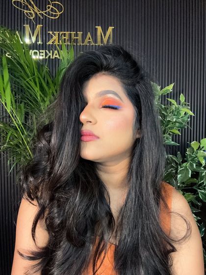 A creative and colorful eye makeup look with closed eyes. The blend of orange and blue is perfect for someone who wants to make a statement at a party.