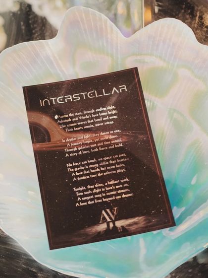 The event's story card, placed in a pearlescent, shell-like dish, tying the poetic narrative of the evening to the physical decor.