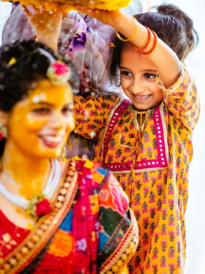 A close-up on the adorable interaction between the bride and the little girl during the Haldi rituals.