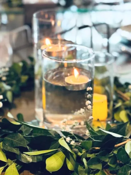 Floating candles and fresh greenery create a serene and beautiful centerpiece for the dining table at the Aqeeqa celebration.