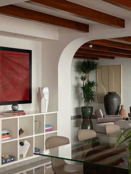 In this Parisian-inspired home, the clean white walls and built-in shelving provide the perfect backdrop for a vibrant red piece of art, demonstrating how neutral spaces can make colors pop.