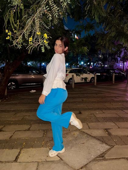 A casual night-out look featuring bright blue wide-leg pants. I paired them with a simple white shirt and a waist belt to cinch the waist and create a flattering shape.