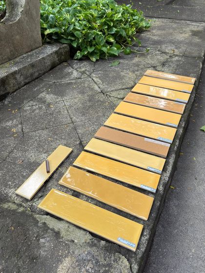 Laying out tile samples in the studio courtyard to see them in natural light. This helps us make the right decision on shades and finishes, especially for projects with a specific color palette.