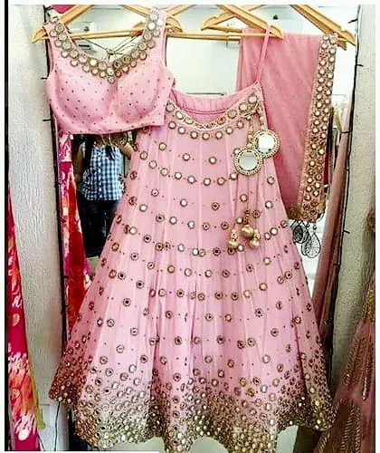 A beautiful pink lehenga choli with traditional mirror work. This style is perfect for festive occasions like Navratri or a friend's mehendi ceremony.
