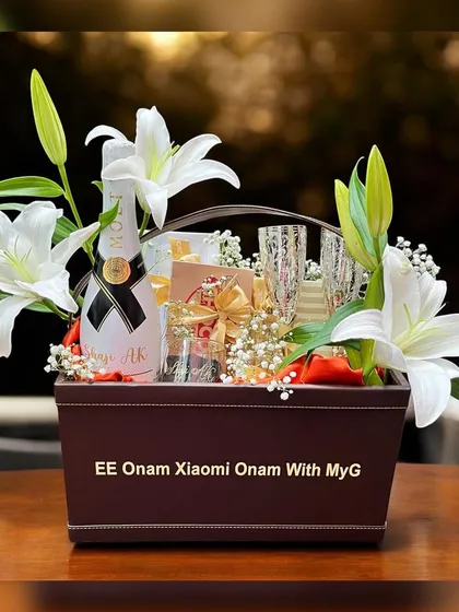 This is a luxury corporate hamper I created for Xiaomi's Onam celebration, presented in a custom-branded leatherette basket with fresh lilies, champagne, and other premium goodies.