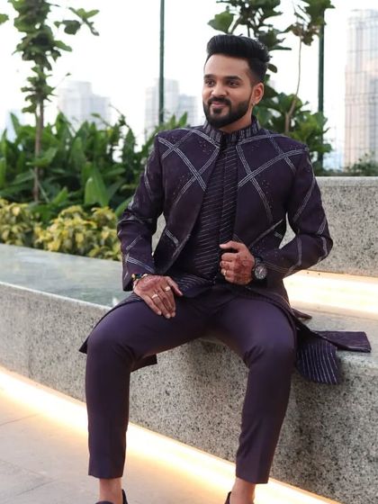 A relaxed pose showing the purple Indo-Western outfit. The combination of the structured jacket and flowing kurta underneath provides a balanced and comfortable fit.