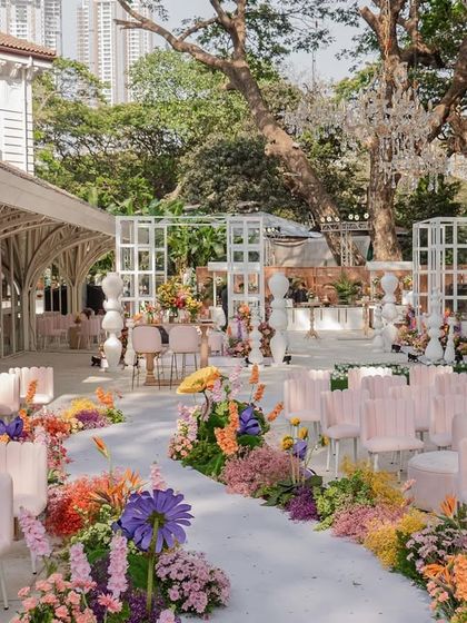 The full ceremony setup for the "Bloom" wedding, showcasing the grand scale of the event with its long floral aisle and abundant seating.