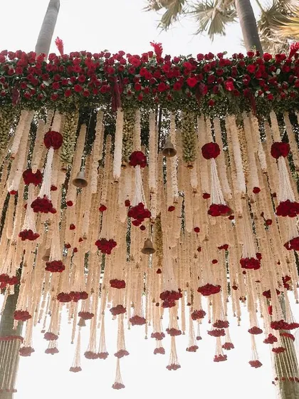The top of the mandap, where a bed of red roses sits atop the hanging floral strings.