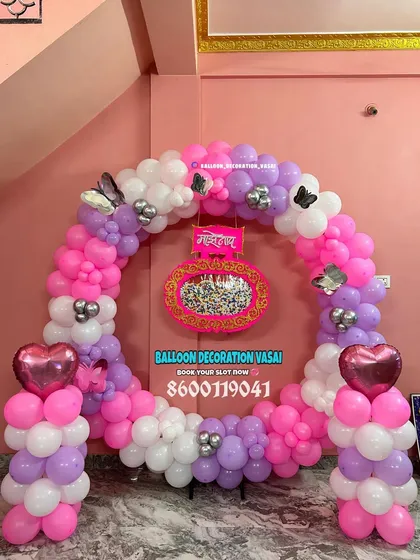 A beautiful ring-shaped backdrop for a Marathi naming ceremony. The pink, purple, and white balloons are accented with butterfly and heart details, framing the traditional "Namkaran" sign in the center.