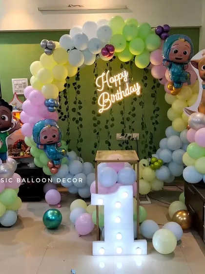 Another view of the Cocomelon first birthday decoration, showing the arrangement of the character cutouts and the light-up number '1'.