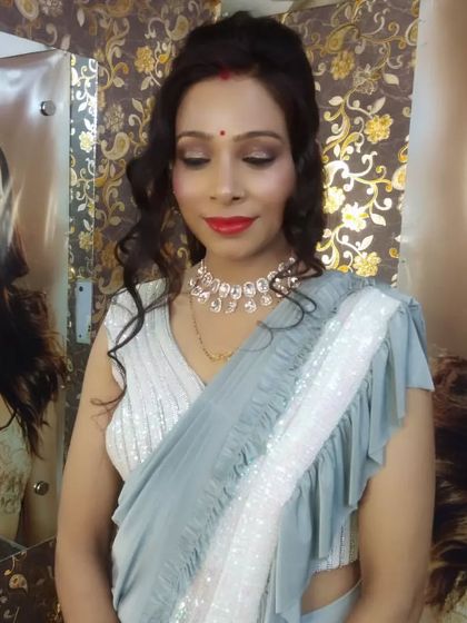 A glamorous party makeup look. The client is wearing a modern ruffled saree, so I gave her a sophisticated makeup look with red lips and soft, open curls.