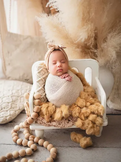 There is nothing more precious than a sleeping newborn. I specialize in creating these peaceful, dreamy portraits, ensuring your baby is safe, comfortable, and beautifully captured. This boho-themed setup with soft, neutral tones and natural textures is perfect for timeless newborn photos.