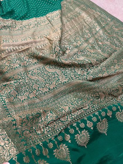 The pallu of another green Banarasi silk saree, this one featuring a mix of floral, paisley, and heart-shaped motifs in a dense jaal weave.