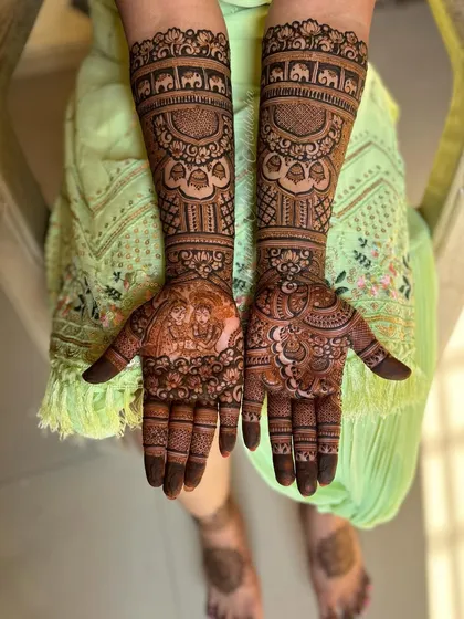 A stunning Radha Krishna design for a bride. The figures are surrounded by intricate patterns and bands of elephants, creating a divine and artistic bridal look.