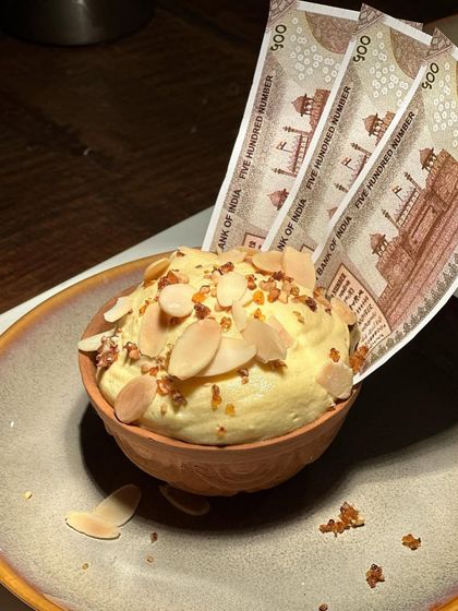 The details of our kulfi dessert, from the toasted almonds to the crisp edible paper. Every element is carefully considered for maximum impact.