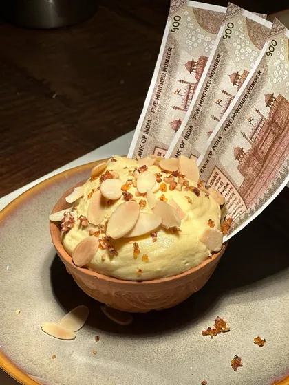 The details of our kulfi dessert, from the toasted almonds to the crisp edible paper. Every element is carefully considered for maximum impact.