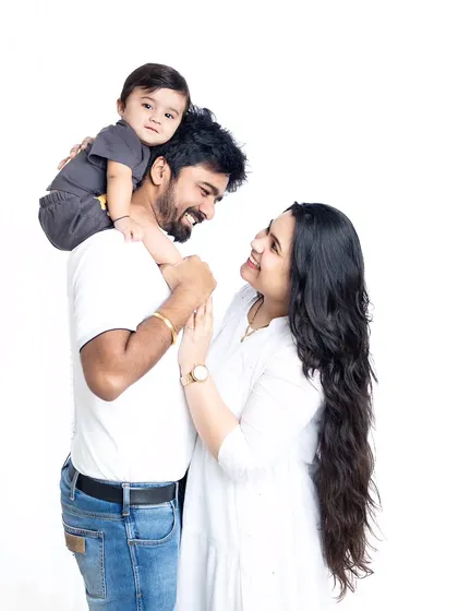 A tender family moment captured in the studio. The simple, light-colored clothing creates a soft and airy feel.