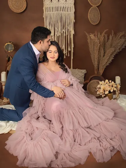 A sweet kiss for the mommy-to-be. This pose in our rustic boho setup, with the expecting father kneeling, creates a romantic and cherished memory.