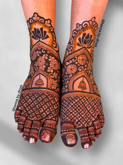 A stunning bridal feet design featuring temple bell motifs. The combination of floral patterns and a dense grid creates a rich and traditional look.