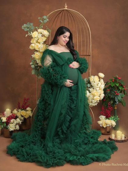 A classic three-quarter portrait that beautifully showcases the baby bump. The deep green of the gown provides a rich, luxurious feel to the photograph.